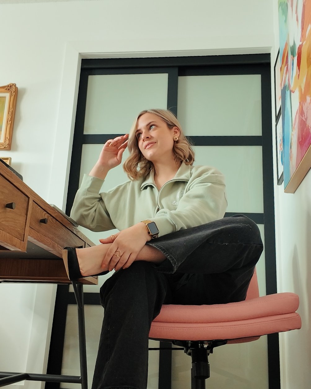 Patti Q Edit Working from her desk in a pink desk chair